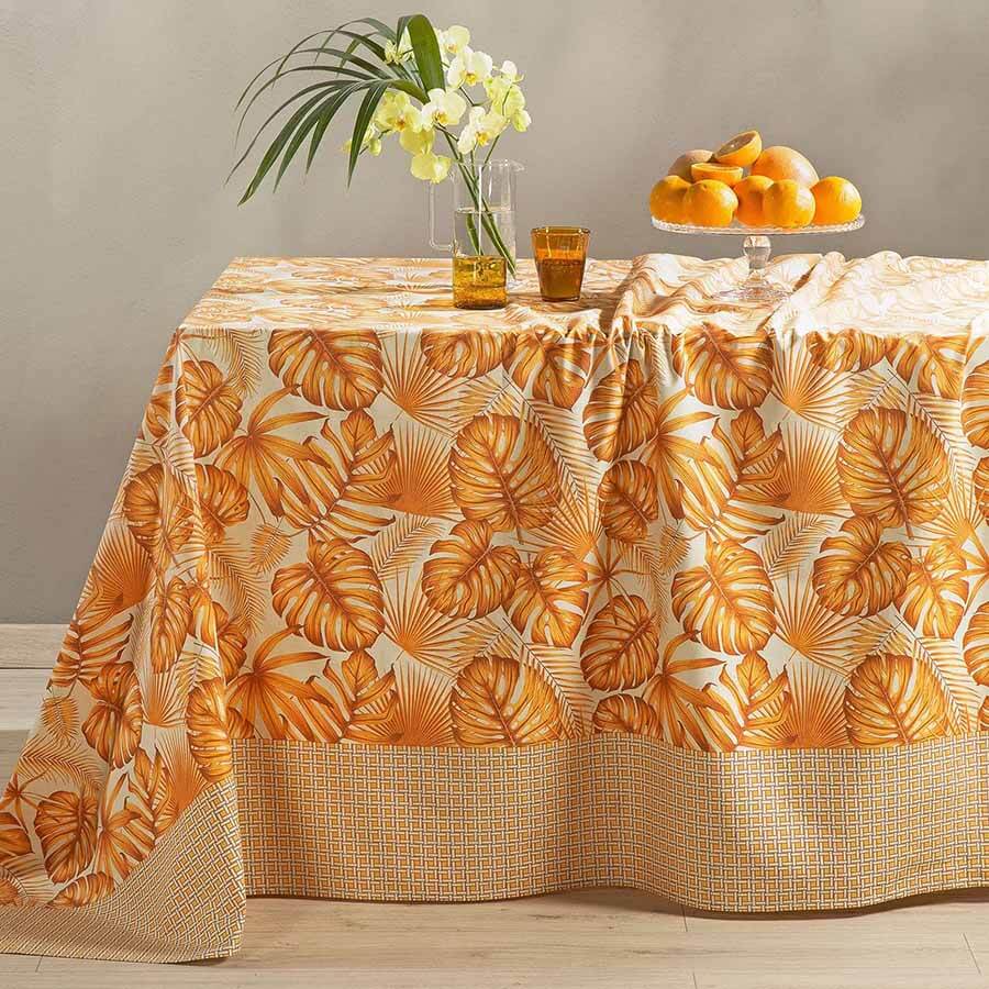 Telo Arredo multiuso Foglie di Caleffi, in puro cotone. Fantasia con bordo geometrico e foglie stampate sul resto del telo. Colore arancio.