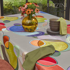 Tovaglia Ellisse di Fazzini, in puro cotone con stampa digitale. La tovaglia Ellisse Fazzini è realizzata con cotone di alta qualità ed è adatta sia per tavoli rettangolari che quadrati. La fantasia geometrica multicolore è caratterizzata da forme morbide e sinuose su fondo grigio sasso, e dona eleganza e originalità al tavolo da pranzo.