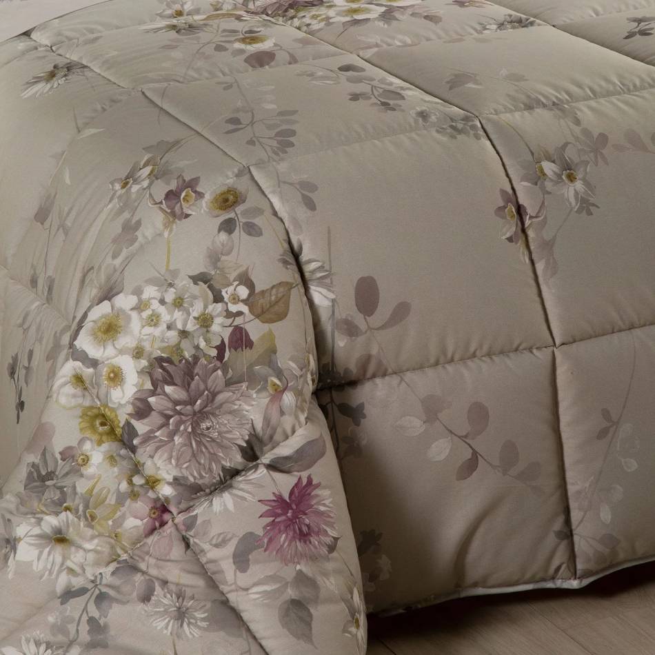 Trapunta invernale matrimoniale Caleffi Aurora, in puro cotone con stampa digitale. Piumone con fantasia floreale dal colore delicato su fondo chiaro. Fondo degradè che passa dal bianco al tortora andando verso il fondo letto. Dettaglio fondo letto.