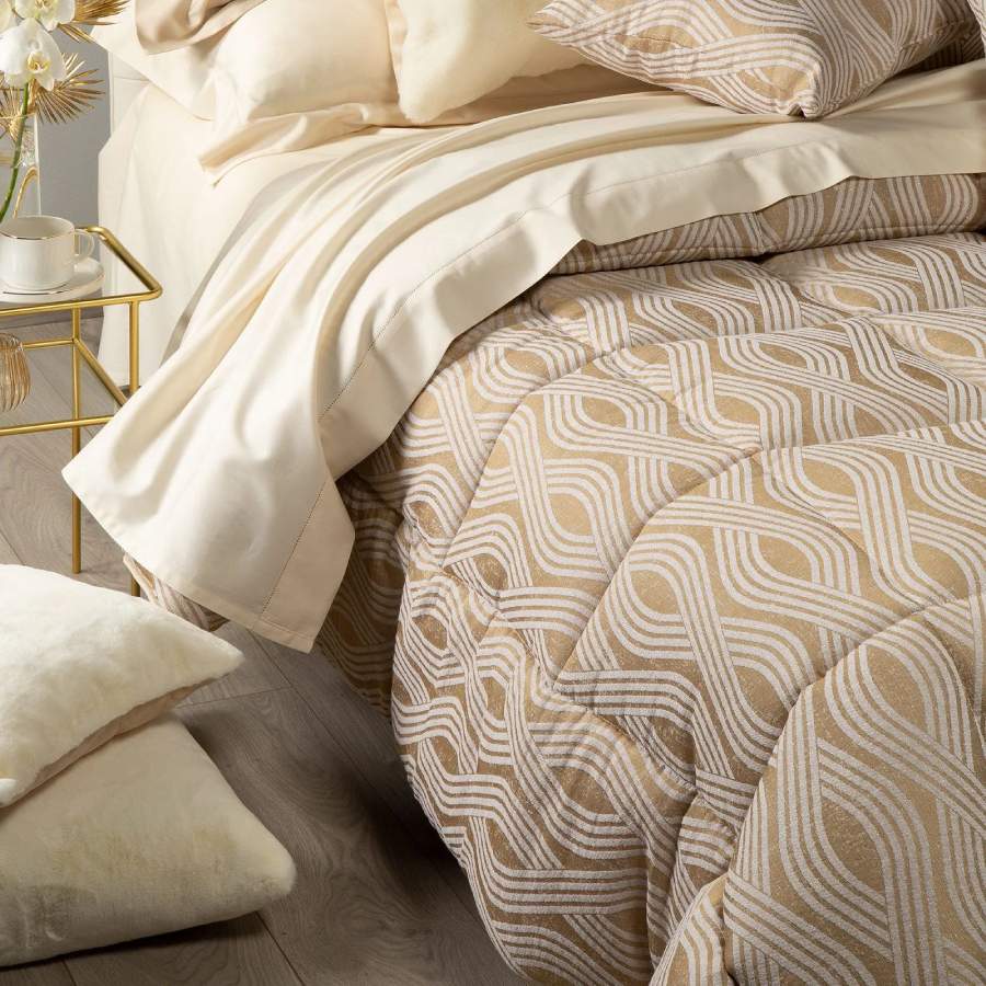 Trapunta invernale matrimoniale Caleffi Abbraccio, in prezioso raso jacquard. Trapuntata a capo e rifinita con angoli arrotondati. Piumone con fantasia moderna dalle forme morbide. Colore oro.