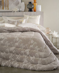 Trapunta Invernale matrimoniale Annarosa di Blumarine, in elegante raso jacquard. Fantasia jacquard a tema floreale colore tortora, con logo Blumarine in preziosi cristalli Swarovski.