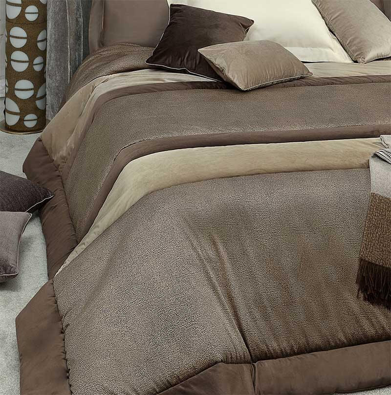 Trapunta invernale Borbonese Avenue matrimoniale in raso di puro cotone e velluto. Il piumone Avenue è caratterizzato da una particolare lavorazione patchwork che unisce due tipi di tessuto diversi: il raso di cotone, con la tipica stampa Borbonese a occhio di pernice, e il velluto in tinta unita marrone e beige.