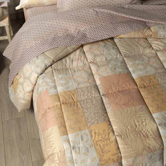 Trapunta Invernale Caleffi Green Village in puro cotone, per letto matrimoniale. Fantasia floreale patchwork dai toni caldi. Variante naturale. Toni del beige, arancio, tortora.