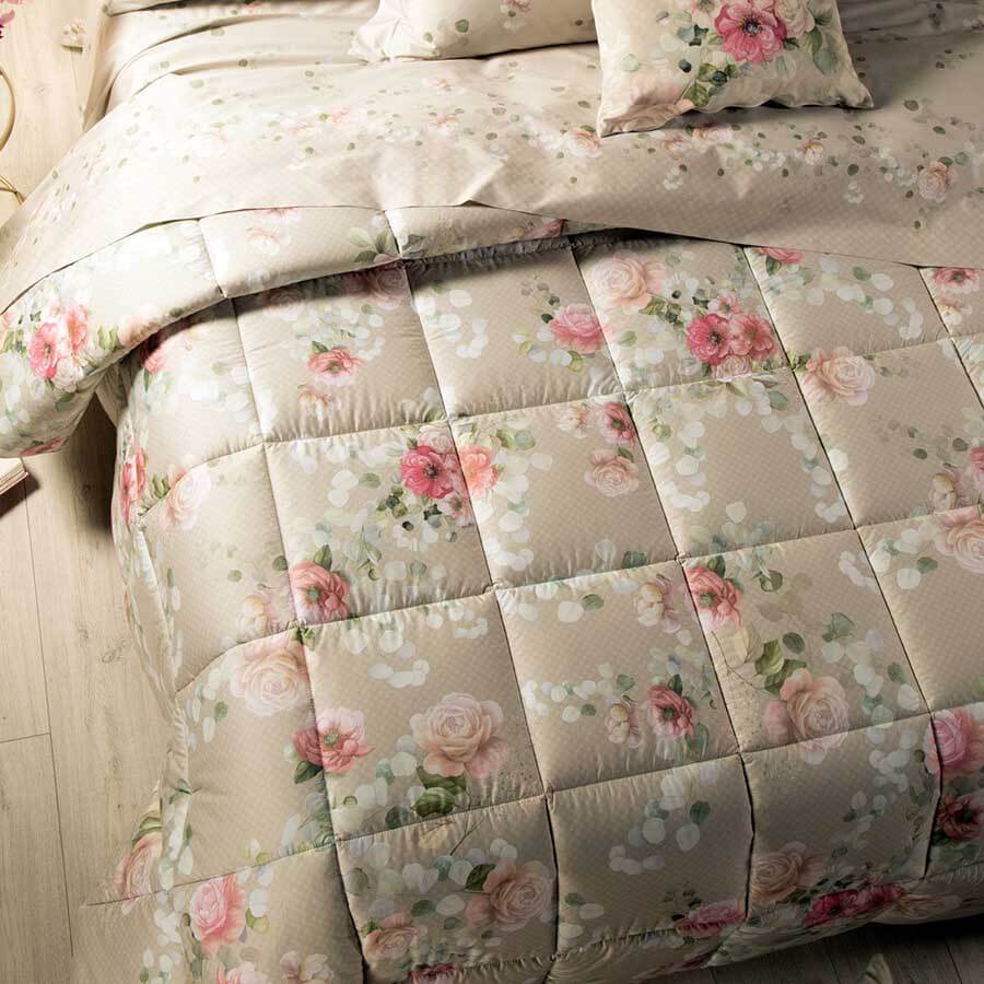 Trapunta invernale matrimoniale Caleffi Giardino Botanico in raso di puro cotone con stampa digitale. Fantasia floreale con fiori rosa e bianchi dai con fondo beige.