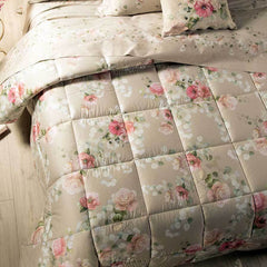 Trapunta invernale matrimoniale Caleffi Giardino Botanico in raso di puro cotone con stampa digitale. Fantasia floreale con fiori rosa e bianchi dai con fondo beige.