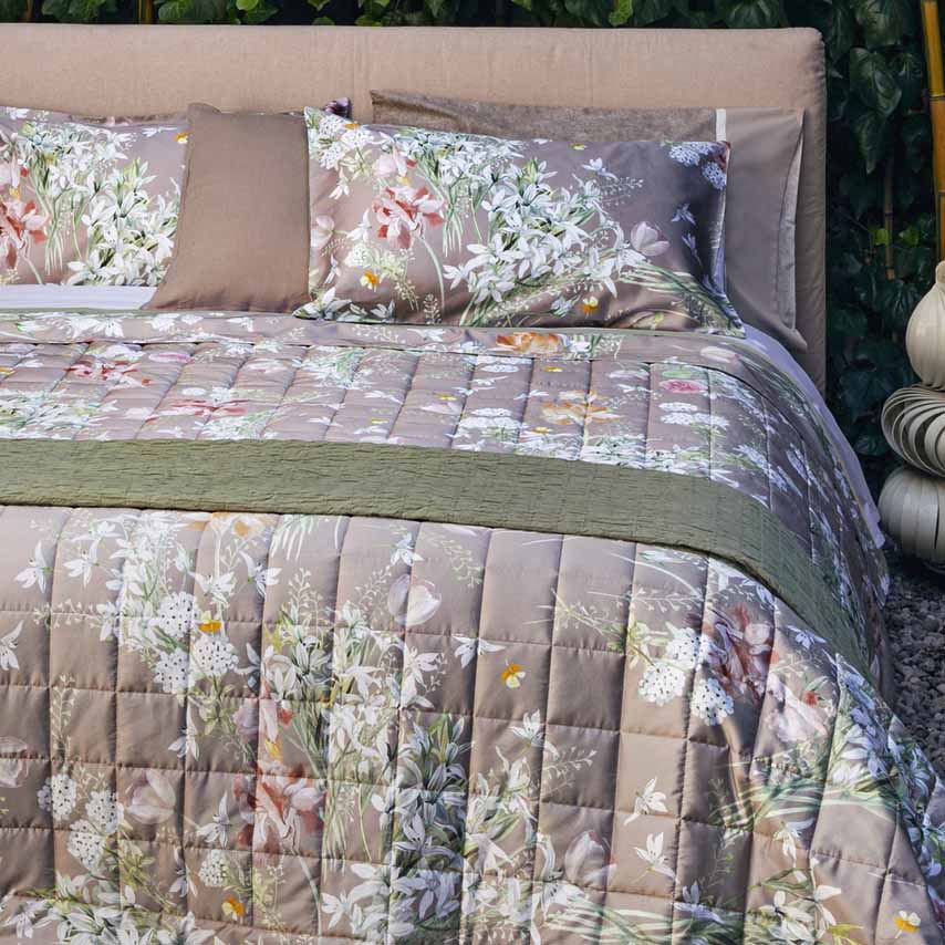 Trapuntino matrimoniale Fazzini Lilia in raso di puro cotone. Trapunta primaverile con fantasia floreale su fondo sasso tortora. Quilt trapunta primaverile con fiori bianchi e colorati.