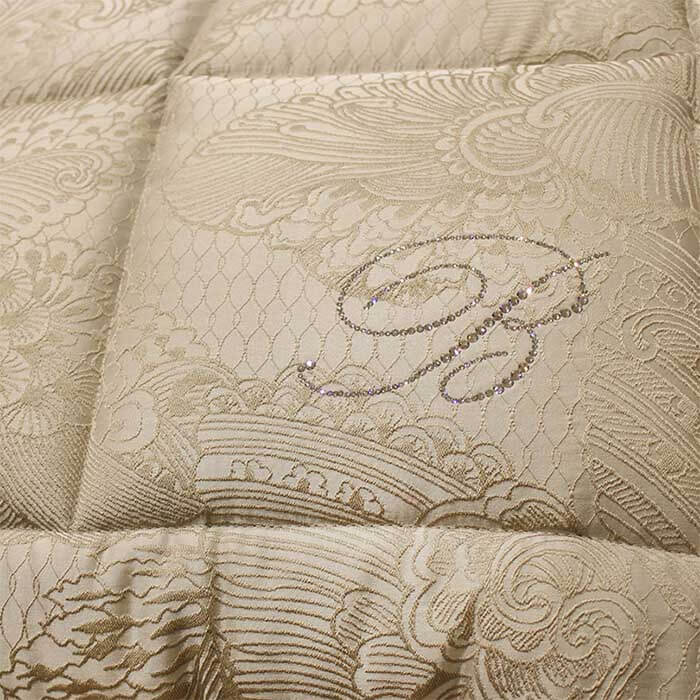 Trapuntino matrimoniale Lisbeth Blumarine con fantasia classica jacquard e logo Blumarine in cristalli Swarovski. Variante betulla.. Dettaglio.