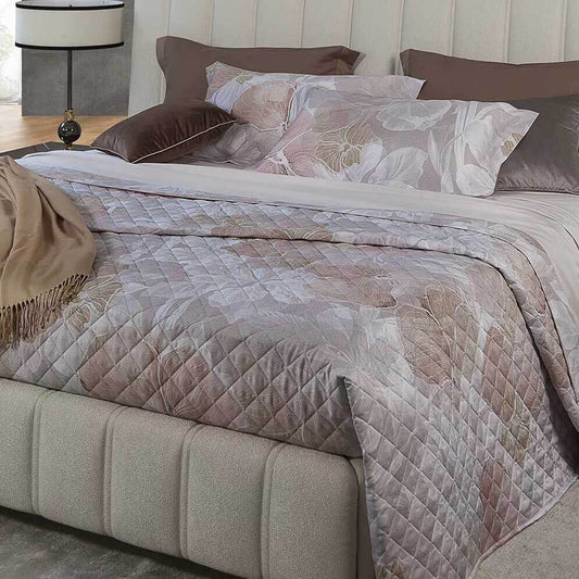 Trapuntino matrimoniale Flower Borbonese, in raso di puro cotone stampato. La trapunta primaverile Flower è caratterizzata da una fantasia floreale dai toni delicati, con fiori color albicocca e fondo grigio/beige con la tipica stampa Borbonese a occhio di pernice. Trapunta rifinita a mano con angoli stondati.