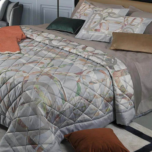 Trapuntino matrimoniale Liberty Borbonese, in raso di puro cotone stampato. La trapunta primaverile Liberty è caratterizzata da una fantasia moderna piazzata dai toni delicati, con simboli e stampe tipiche del marchio Borbonese. Variante di colore grigio perla.