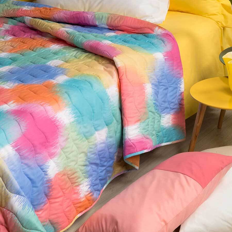 Trapuntino Caleffi Murano in microfibra. Trapunta primaverile caratterizzata da una fantasia moderna, con macchie multicolor stile acquerello, colore corallo. Disponibile nella misura per letto singolo, piazza e mezza e matrimoniale.