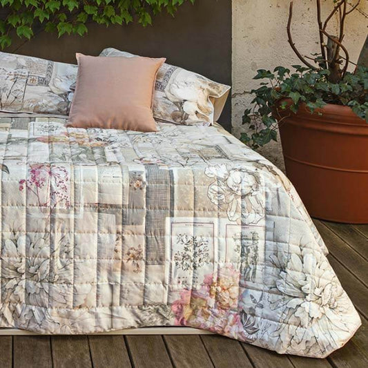 Trapuntino matrimoniale Fazzini Divina in raso di puro cotone. Fantasia patchwork ispirata alla Divina Commedia, che unisce fiori a scritte e incisioni. Colore rosa/naturale.