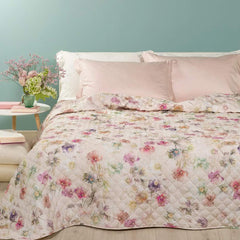 Trapuntino matrimoniale Caleffi Lilac in puro cotone con stampa digitale. Trapunta primaverile con fantasia floreale con fiori colorati dai toni delicati su fondo beige chiaro.
