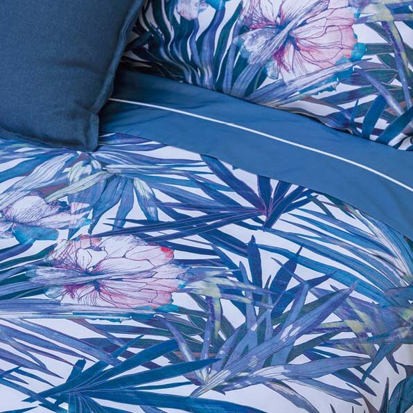 Trapuntino matrimoniale Fazzini Papiro in raso di puro cotone. Trapunta primaverile con fantasia floreale: foglie e fiori blu e rosa su fondo bianco.