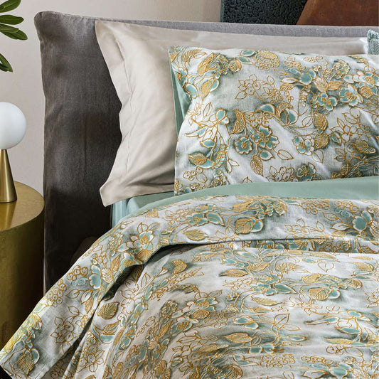 Trapunta invernale matrimoniale Fazzini Chinoiserie, in raso di puro cotone.  La passione per le ceramiche orientali anima la collezione Chinoiserie. Il disegno floreale variente surf (verde acqua) emerge sul fondo dall'effetto acquerellato e diventa tridimensionale grazie al profilo floccato e dorato. Il piumone Chinoiserie ha una fantasia floreale dorata su fondo verde acqua. 