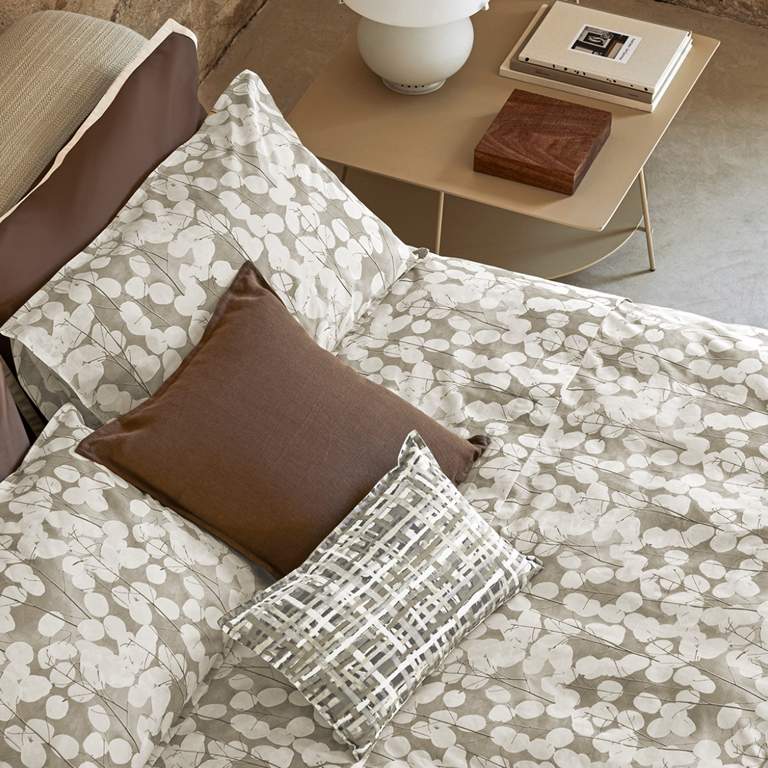 Trapunta primaverile matrimoniale Fazzini Lunaria, in percalle di puro cotone. Il trapuntino Lunaria presenta una fantasia floreale dallo stile moderno, con fiori chiari su fondo grigio. Quilt
