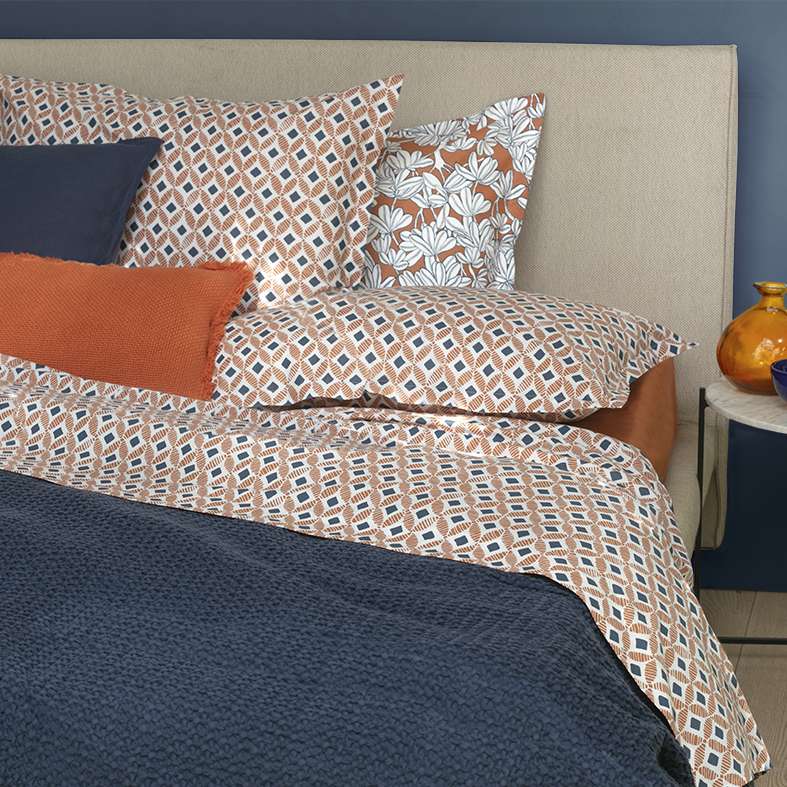 Completo lenzuola Fazzini Path, in puro cotone di ottima qualità. Disponibile nella misura per letto singolo, piazza e mezza e matrimoniale.  Il completo lenzuola Path è caratterizzato da un'allegra fantasia geometrica colore copper arancione. Il lenzuolo con angoli è in tinta unita.