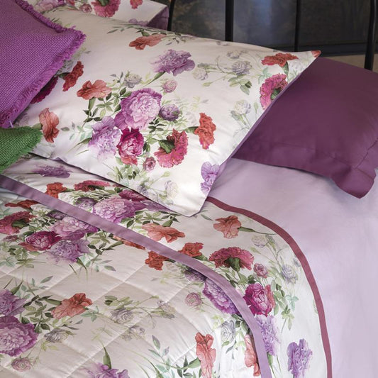 Completo lenzuola matrimoniale Fazzini Summer, in percalle e raso di puro cotone.  La fantasia Summer è ispirata dalla bellezza del garofano. Il disegno romantico e vivido dei fiori decora le federe e la balza superiore del lenzuolo di sopra, entrambe in raso di cotone. Colore rosa glicine. La fantasia è presente sulla faccia superiore delle federe e sulla balza del lenzuolo di sopra, entrambe in raso di cotone. Il resto del completo è in percalle tinta unita rosa.