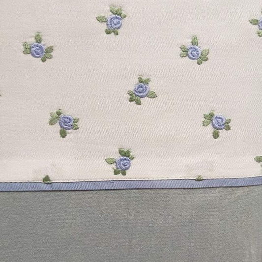 Completo lenzuola matrimoniale Fazzini Spring in flanella di puro cotone. Le federe e il lenzuolo di sopra presentano una fascia bianca con roselline azzurre ricamate. Il resto del completo è in tinta unita verde acqua.