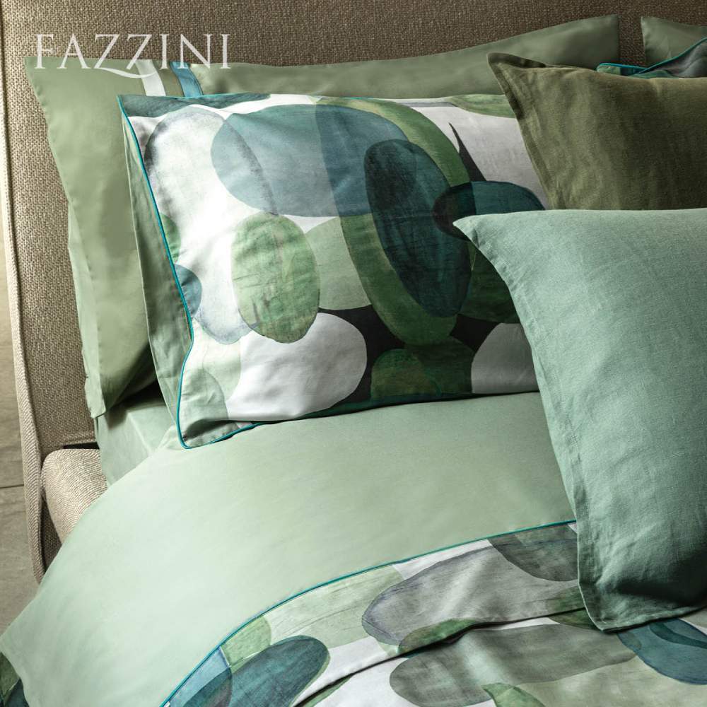 Completo lenzuola matrimoniale Fazzini Bling, in percalle e raso di cotone. Il motivo morbido, che ricorda le forme dei ciottoli, è declinato nei toni del verde, che riprendono il mondo acquatico, e in una vivace variante multicolor. Variante verde. Il lato superiore delle federe e la balza del lenzuolo di sopra sono in raso di cotone stampato in digitale. Il resto del completo è in percalle di cotone tinta unita