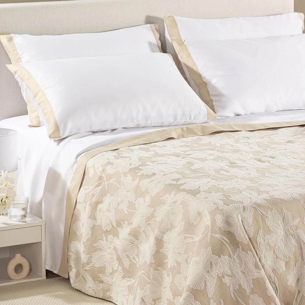 Copriletto estivo Cala Luna fantasia jacquard con foglie chiare su fondo naturale beige.