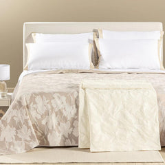 Copriletto estivo Cala Luna fantasia jacquard con foglie chiare su fondo naturale beige o panna.