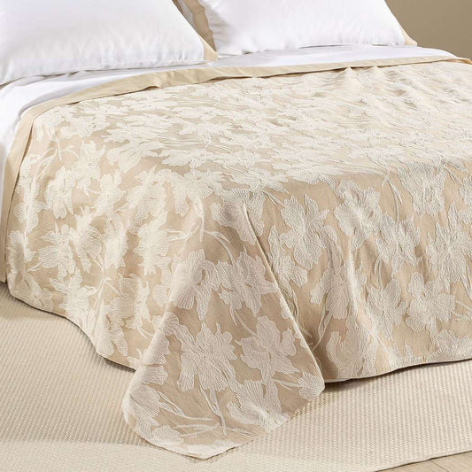 Copriletto estivo Cala Luna fantasia jacquard con foglie chiare su fondo naturale beige.