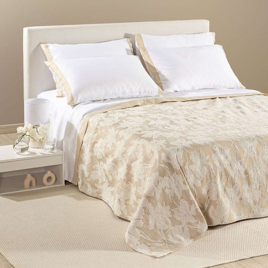 Copriletto estivo Cala Luna fantasia jacquard con foglie chiare su fondo naturale beige.