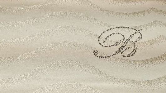 Copriletto Estivo matrimoniale Jasmine di Blumarine, in elegante raso jacquard. La trapunta Jasmine è caratterizzata da un sensuale motivo jacquard a onde ed è arricchita dal logo Blumarine in preziosi cristalli Swarovski. Disponibile nella variante di colore ecrù (avorio)