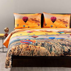Completo copripiumino matrimoniale Cappadocia di Caleffi, in puro cotone anallergico e traspirante. Fantasia che ritrae i colori caldi di un tramonto sul tipico paesaggio della Cappadocia, sorvolato da mongolfiere colorate. Stampato in digitale e in alta definizione