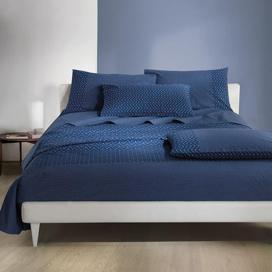 Lenzuolo Copriletto matrimoniale Los Roques in puro cotone. Realizzato in Italia da Gabel.  Il completo lenzuola Los Roques presenta una moderna fantasia geometrica blu. Il lenzuolo di sopra e le federe sono in fantasia. Il lenzuolo con angoli presenta una microfantasia di colore blu