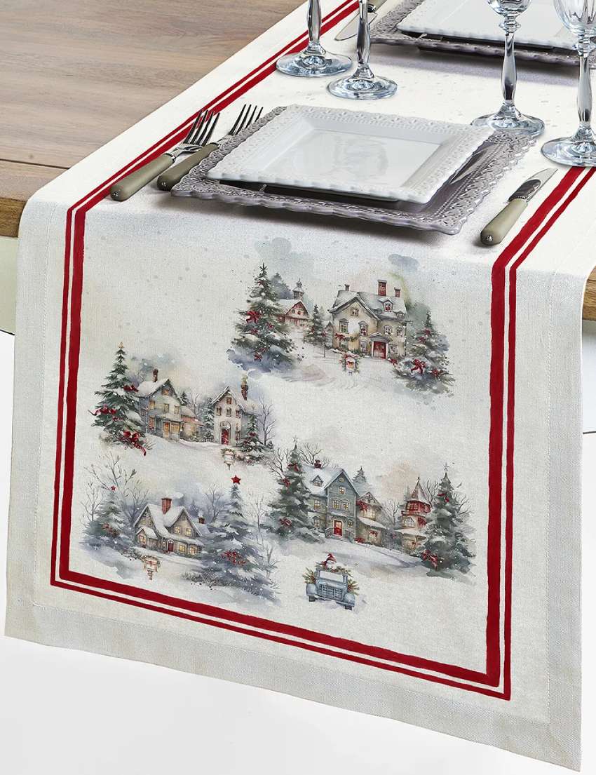 Corsia natalizia Frozen di Tessitura Randi. 
Runner fantasia con paesaggio natalizio: case innevate e abeti addobbati su fondo chiaro. Il tutto racchiuso in una cornice di colore rosso.