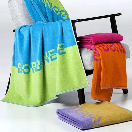Telo mare Borbonese&nbsp;Trinidad, in spugna di puro cotone.  Telo mare Borbonese in spugna di cotone stampata con logo Borbonese, con 3 abbinamenti di colore: fuxia/arancio, viola/ocra, turchese/verde.  Spugna di cotone 380 g/mq. Misura 90x160 cm.