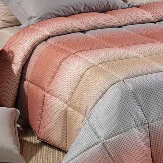 Trapunta invernale Caleffi Larry. Piumone con fantasia geometrica degradè grigio e corallo.