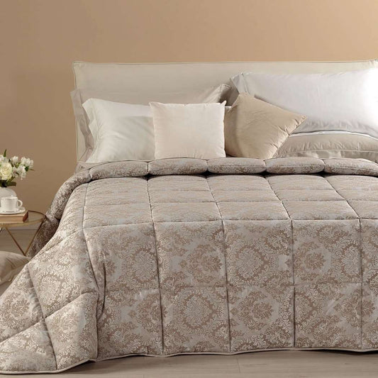 Trapunta invernale matrimoniale Caleffi Mida, in prezioso raso jacquard. Il piumone Mida presenta una fantasia dallo stile classico, nella variante di colore naturale tortora.