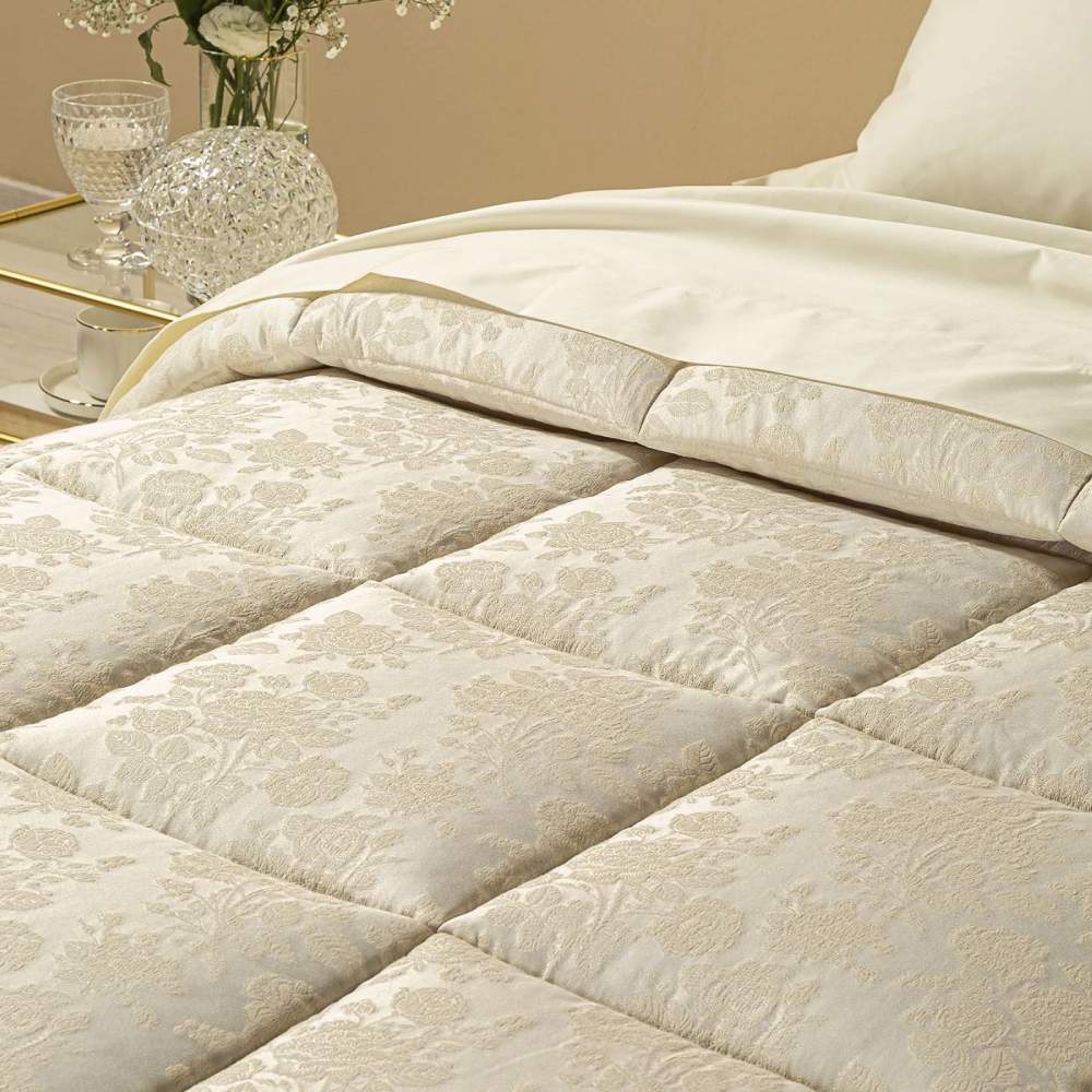 Trapunta invernale matrimoniale Caleffi Belfiore, in prezioso raso jacquard.   Il piumone Belfiore è caratterizzata da una delicata fantasia floreale tono su tono, nella variante di colore avorio.  dettaglio fantasia floreale