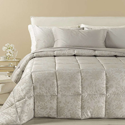 Trapunta invernale matrimoniale Caleffi Narciso, in prezioso raso jacquard. Il piumone Narciso è caratterizzato da una delicata fantasia floreale tono su tono. Colore sabbia tortora