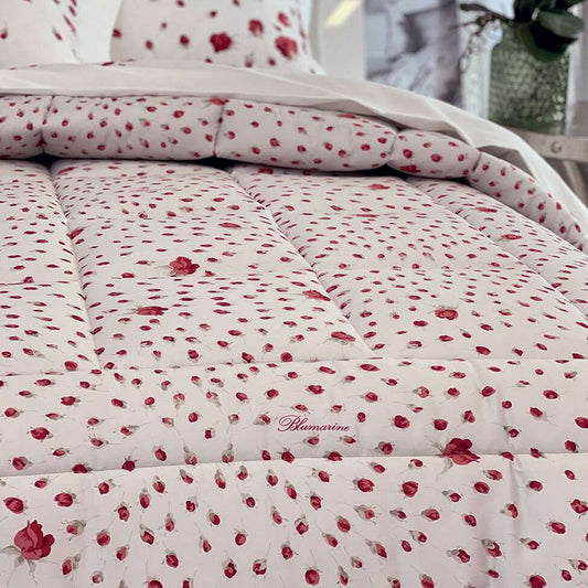Trapuntino matrimoniale Sogno di Blumarine, in raso di puro cotone stampato. La trapunta primaverile Sogno presenta una romantica fantasia floreale. Disponibile la variante con fondo bianco e fiorellini di colore rosso
