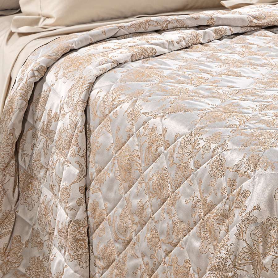 Trapuntino matrimoniale Caleffi Fioralba, in elegante raso jacquard.La trapunta primaverile Fioralba presenta una delicata fantasia floreale tono su tono. Colore tortora con venature bronzo/dorato.