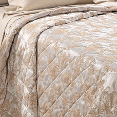 Trapuntino matrimoniale Caleffi Fioralba, in elegante raso jacquard.La trapunta primaverile Fioralba presenta una delicata fantasia floreale tono su tono. Colore tortora con venature bronzo/dorato.