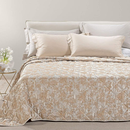 Trapuntino matrimoniale Caleffi Fioralba, in elegante raso jacquard.La trapunta primaverile Fioralba presenta una delicata fantasia floreale tono su tono. Colore tortora con venature bronzo/dorato.
