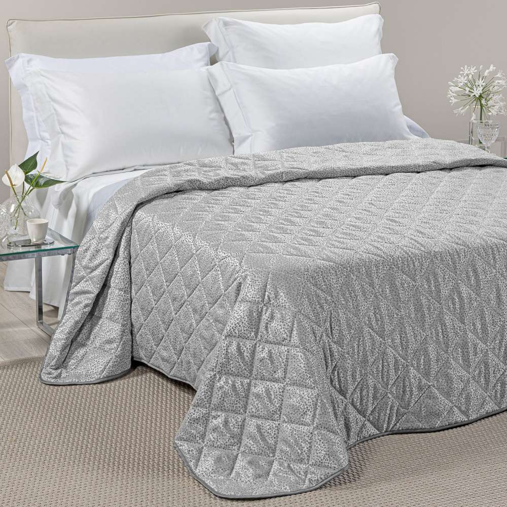 Trapuntino matrimoniale Caleffi Perleè, in elegante raso jacquard.La trapunta primaverile Perleè è caratterizzata da una fantasia geometrica moderna a puntini, colore grigio