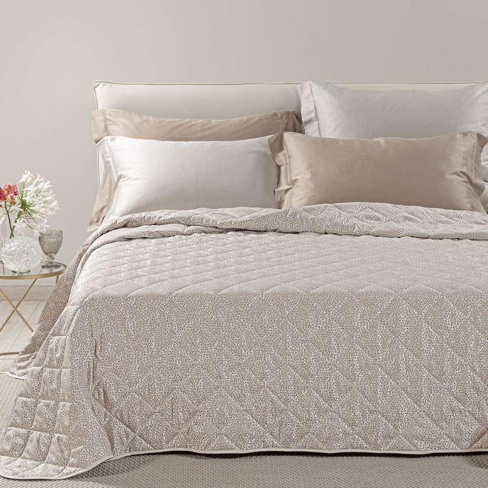 Trapuntino matrimoniale Caleffi Perleè, in elegante raso jacquard.La trapunta primaverile Perleè è caratterizzata da una fantasia geometrica moderna a puntini, colore tortora