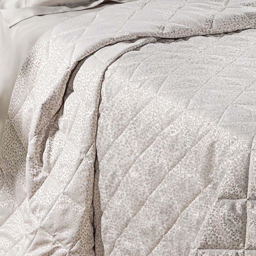 Trapuntino matrimoniale Caleffi Perleè, in elegante raso jacquard.La trapunta primaverile Perleè è caratterizzata da una fantasia geometrica moderna a puntini, colore vaniglia