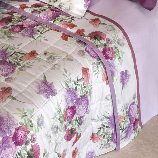 Trapunta primaverile matrimoniale Fazzini Summer, in raso di puro cotone. La fantasia del trapuntino Summer ritrae una distesa lussureggiante di garofani. Il disegno romantico e vivido dei fiori decora la faccia superiore del quilt in raso di cotone. La collezione è proposta nei toni romantici del rosa e del glicine.