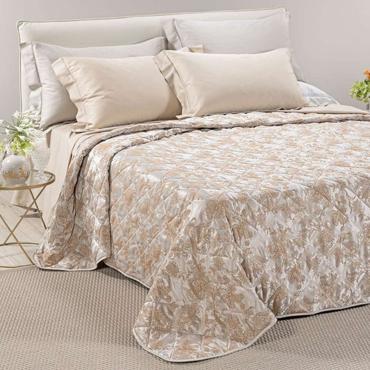 Trapuntino matrimoniale Caleffi Fioralba, in elegante raso jacquard.La trapunta primaverile Fioralba presenta una delicata fantasia floreale tono su tono. Colore tortora con venature bronzo/dorato.