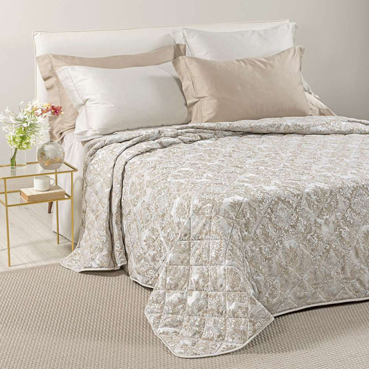 Trapuntino matrimoniale Caleffi Mida, in elegante raso jacquard.La trapunta primaverile Mida presenta una fantasia dallo stile classico, nella variante di colore naturale (tortora)