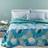 Trapunta primaverile matrimoniale Caleffi Cosmo. Fantasia geometrica multicolore dallo stile moderno, con forme che ricordano pianeti ed eclissi.. variante blu