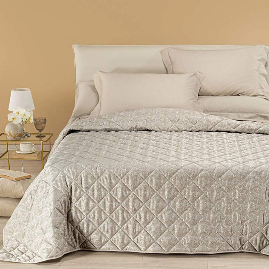Trapuntino matrimoniale Caleffi Interiors in raso jacquard.La trapunta primaverile Interiors presenta una fantasia moderna ma delicata, con foglie che si intersecano in una fitta trama. Copriletto trapuntato colore bosco tortora.