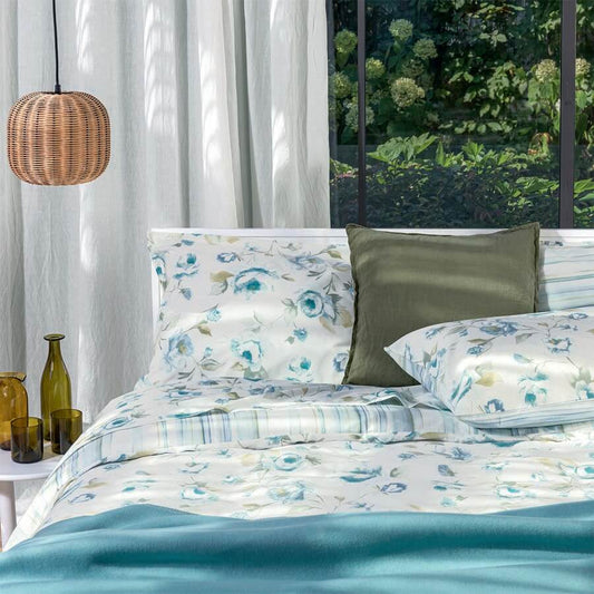 Parure Copripiumino matrimoniale Fazzini Pergolato in puro cotone.  Il copripiumino Pergolato presenta una fantasia doubleface di colore azzurro. Un lato del sacco e delle federe presenta una fantasia floreale, l'atro lato una fantasia a righe, sulle tonalità del celeste/verde acqua.