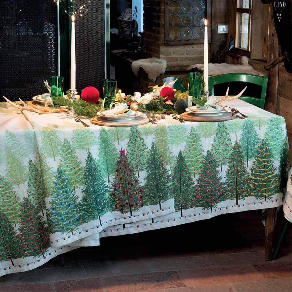 Tovaglia natalizia Fairy Trees in puro lino di Tessitura Toscana Telerie.   Fantasia su fondo chiaro, con abeti verdi addobbati per il Natale.  Misura rettangolare x12 (170x270 cm).